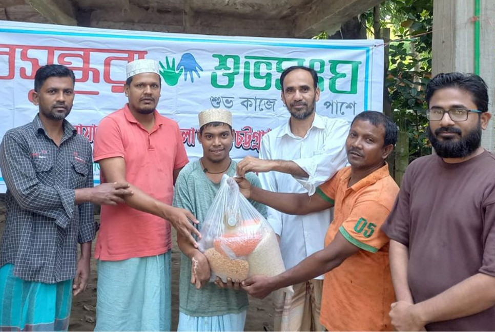 Shuvosangho stands by rickshaw-puller Mohiuddin with food aid
